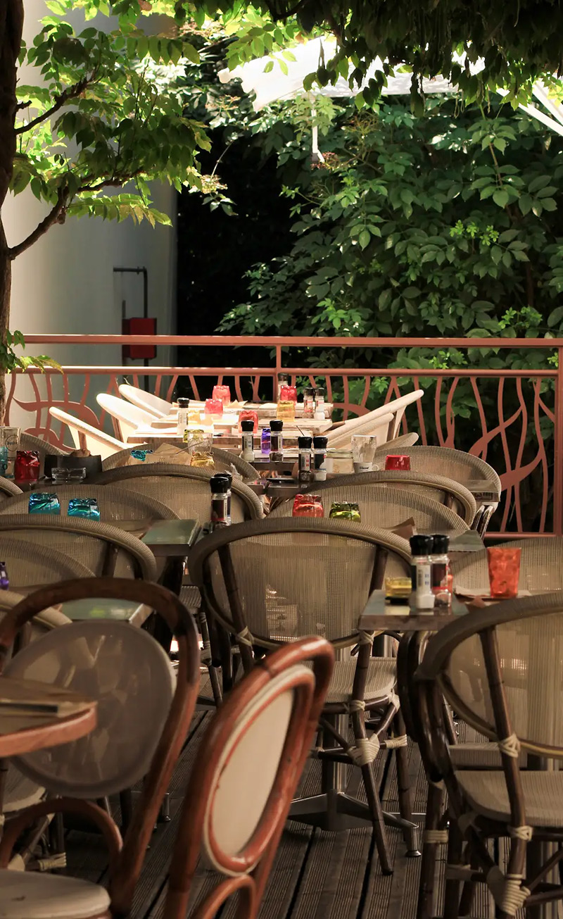 Une table en terrasse avec vue du les jardins